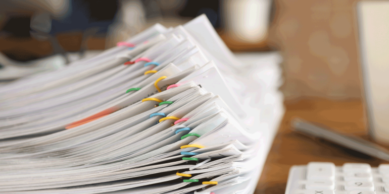 Lot of documents fastened with multicolored paper clips lying on table closeup-Image credit-iStock-1313642712