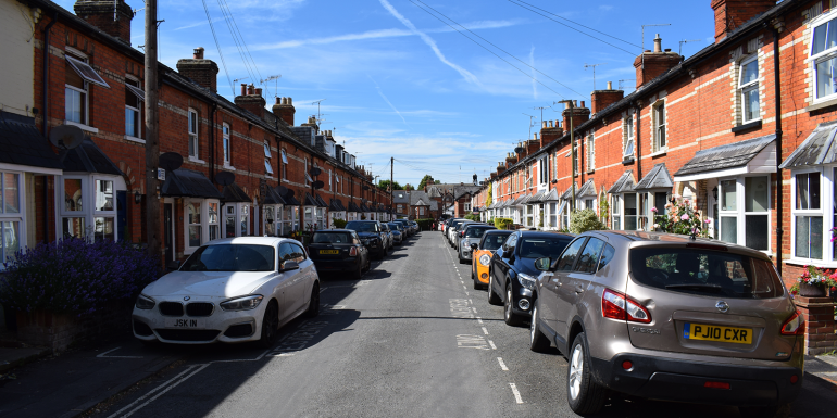 cars occupy a residential street.CREDIT_shutterstock_2482621379