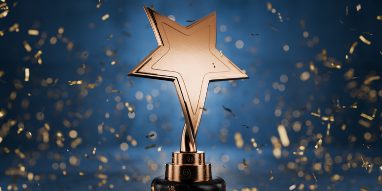 Gold star on a blue background as a reward. CREDIT_iStock-2062707205