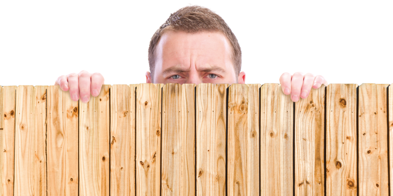 man looking over fence. CREDIT_istock-155159978