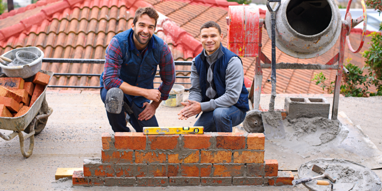 construction bricklayer men building brick wall. CREDIT_shutterstock_2440987653