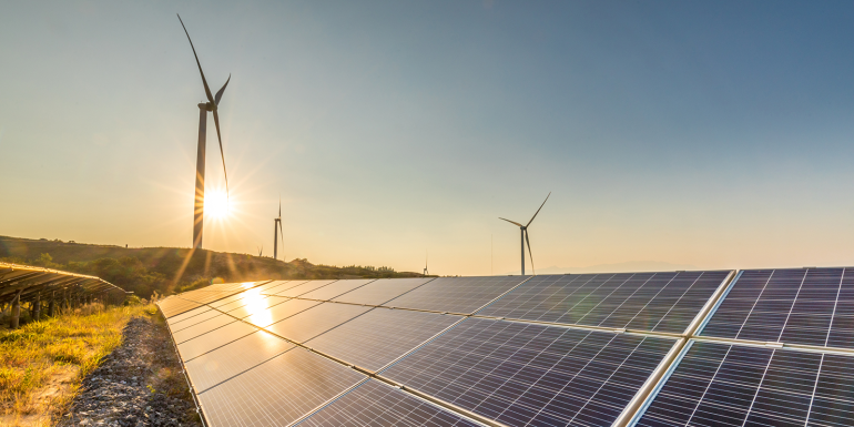 Solar panels and wind turbines at sunset.CREDIT_iStock-1032683612