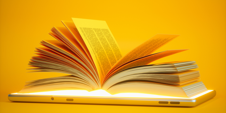 Open Book On Digital Tablet With Yellow Background.credit_istock-1305993250.