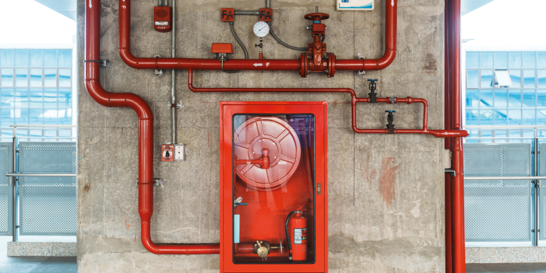 Fire extinguisher and water pump system on the wall, istock-1445984884