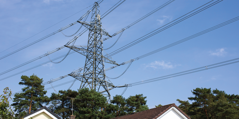 High volatge electricity power lines running through a housing estate in Verwood, Dorset, UK.CREDIT_iStock-2174879745