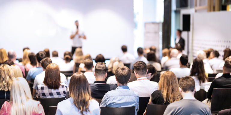 Speaker giving a talk in conference hall at business event.CREDIT_Shutterstock-1117902242