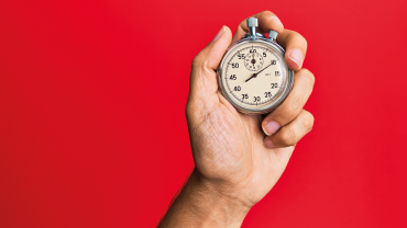 Hand of young hispanic man using stopwatch over isolated red background Image credit | iStock