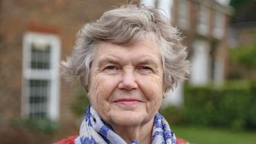 Outdoor headshot of senior woman in sweater and scarf . istock-1288921154