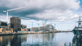 View of the Liffey river in Dublin showing city buildings in constructions and cranes. Warship docked on the river. Image credit - Shutterstock - 1510234517