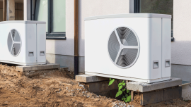 Two air source heat pumps installed outside of new and modern city house under construction-Image credit-Shutterstock-2350417021