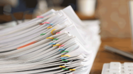 Lot of documents fastened with multicolored paper clips lying on table closeup-Image credit-iStock-1313642712
