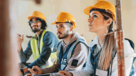 Three people are listening to their foreman on a construction-Image credit-iStock-1465962688