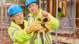 Construction Worker Learning How To Use A Builders Level-CREDIT-iStock-647707924
