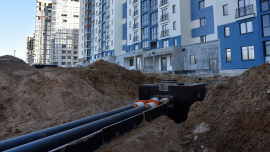 Laying heating pipes in a trench at construction site.CREDIT-shutterstock-1705044463