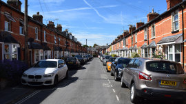 cars occupy a residential street.CREDIT_shutterstock_2482621379