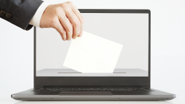 Man Putting a Ballot into a Laptop.CREDIT_shutterstock_1728858028