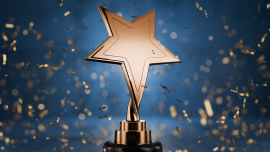 Gold star on a blue background as a reward. CREDIT_iStock-2062707205