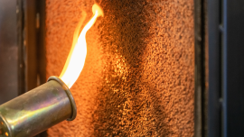 Close up of a flame torch testing flame retardant material, demonstrating fire resistance and safety. shutterstock_2473469235