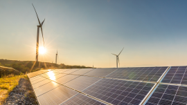 Solar panels and wind turbines at sunset.CREDIT_iStock-1032683612