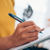 woman hand writing on clipboard with a pen. Credit_iStock-1434437996