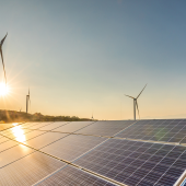 Solar panels and wind turbines at sunset.CREDIT_iStock-1032683612