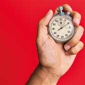 Hand of young hispanic man using stopwatch over isolated red background Image credit | iStock