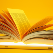 Open Book On Digital Tablet With Yellow Background.credit_istock-1305993250.