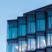 Modern glass facade of new architecture in berlin at blue hour. CREDIT_istock-1290315737