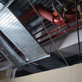 Services have been installed without allowance for fire stopping access and the fire-resisting steel encasement has been installed too close to the cable tray