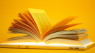 Open Book On Digital Tablet With Yellow Background.credit_istock-1305993250.